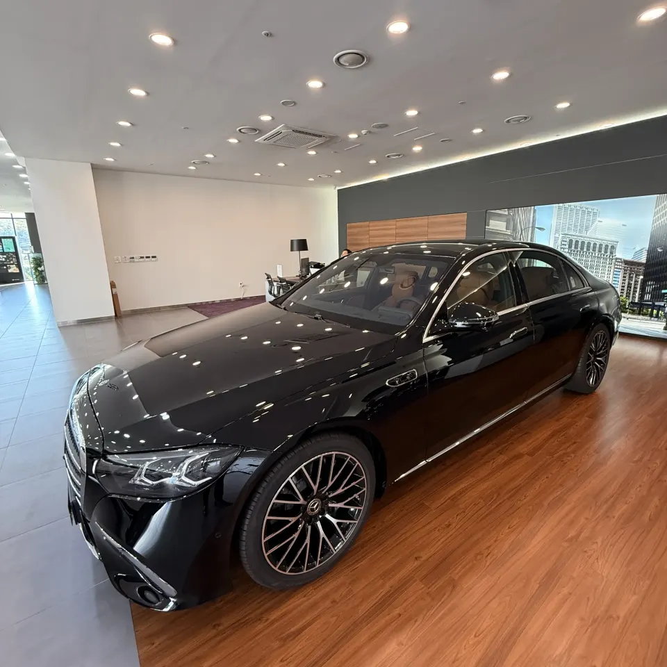 전시장에 전시된 검은색 신형 벤츠 S500 세단 근접 전면 사선