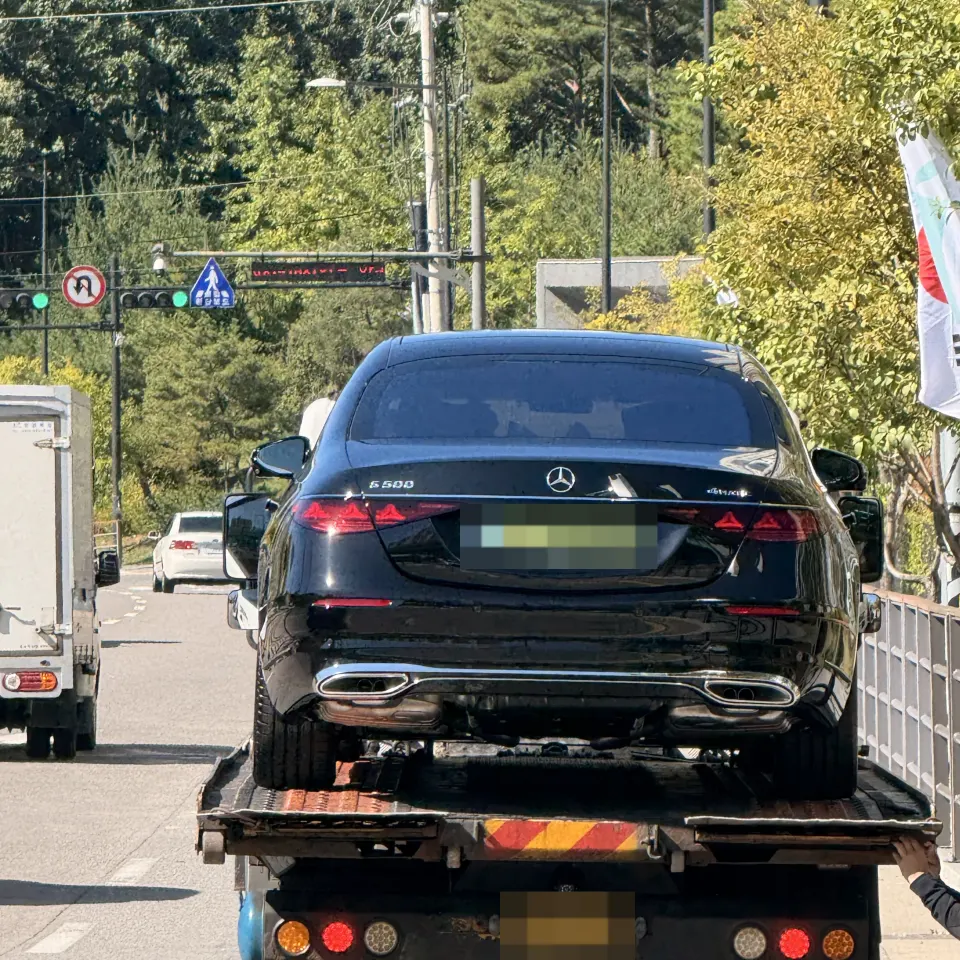 탁송 트럭에 실려 이동 중인 검은색 벤츠 S500 세단 후면