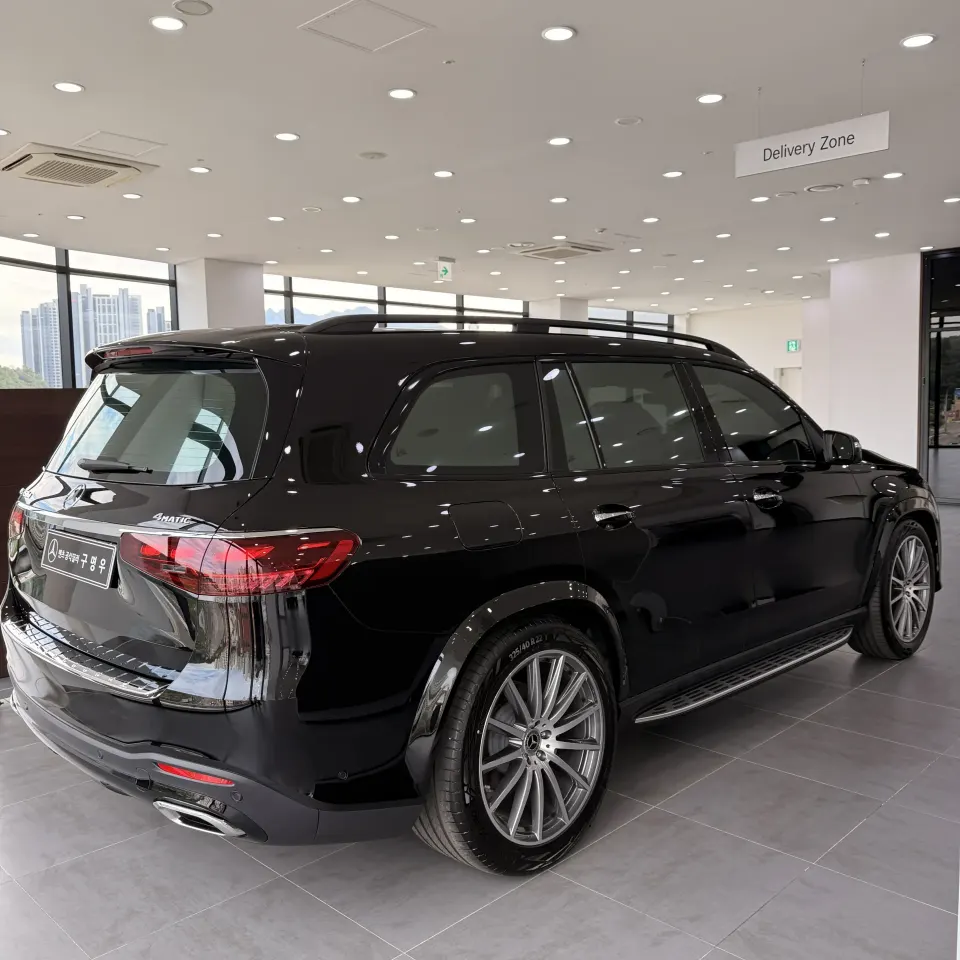전시장에 놓인 검은색 벤츠 GLS SUV 후면 사선